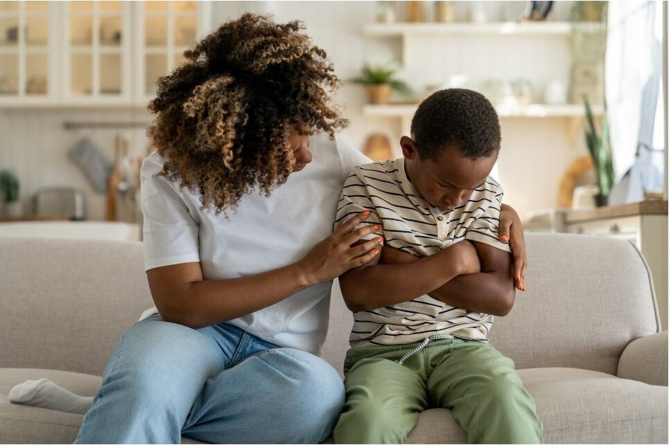 An adult family member using CareBridge in an authentic home environment while supporting a young child (approximately ages 2 to 6).